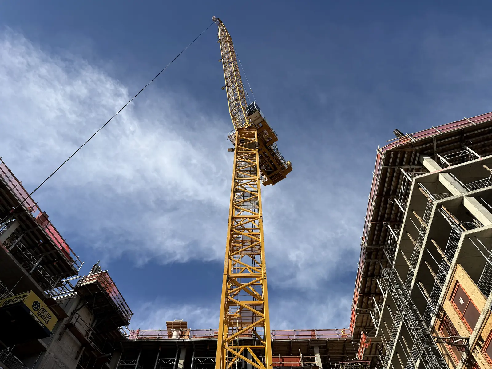 Tower crane rising over a commercial building under construction