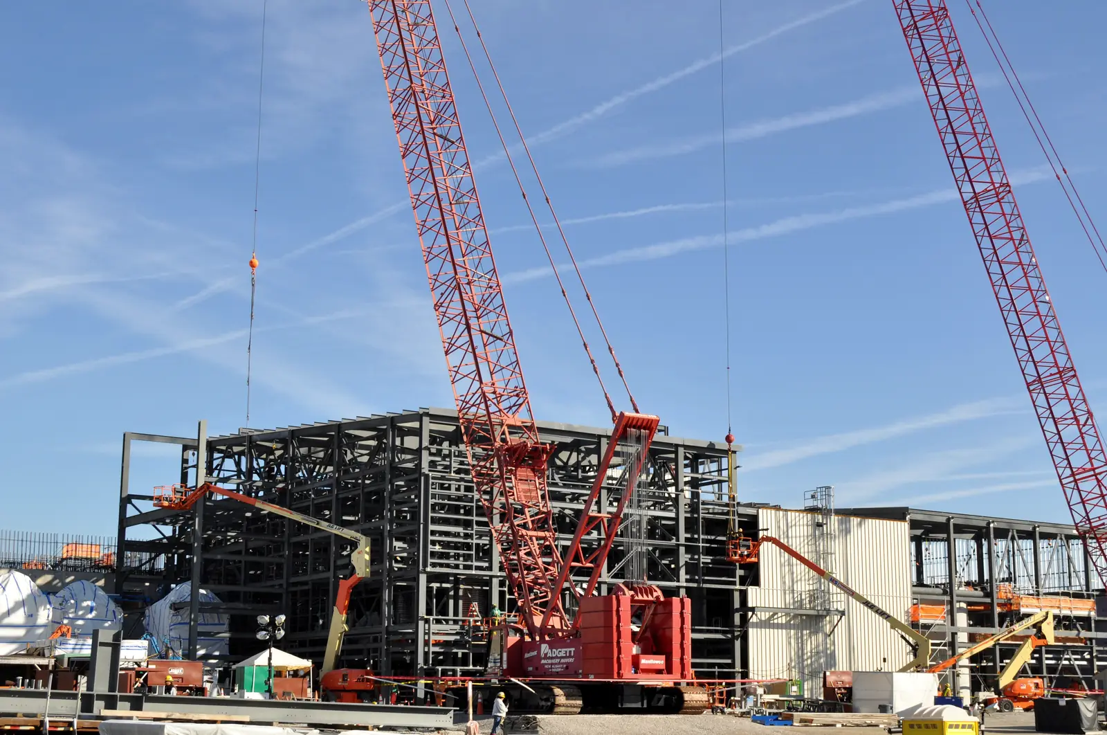 Crawler cranes lifting structural steel on a large industrial project