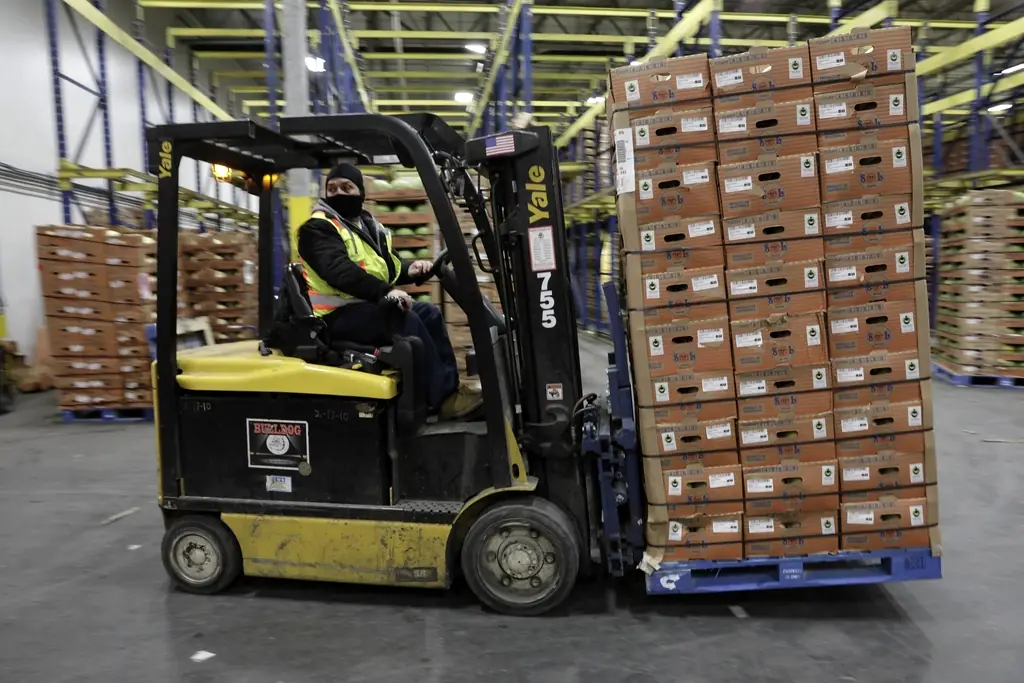 Forklift moving palletised stock inside a distribution warehouse