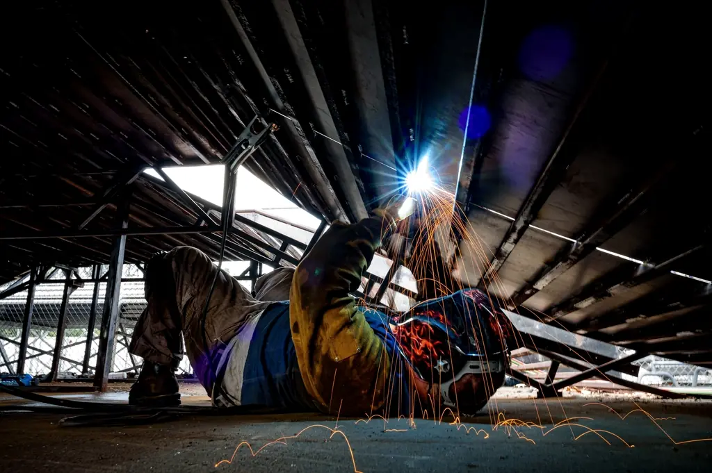 Welder working overhead on a steel structure
